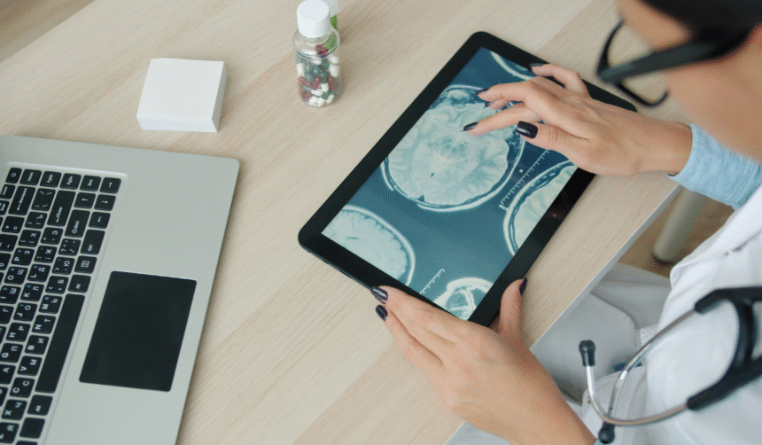 Doctors reviewing medical scans on a tablet.